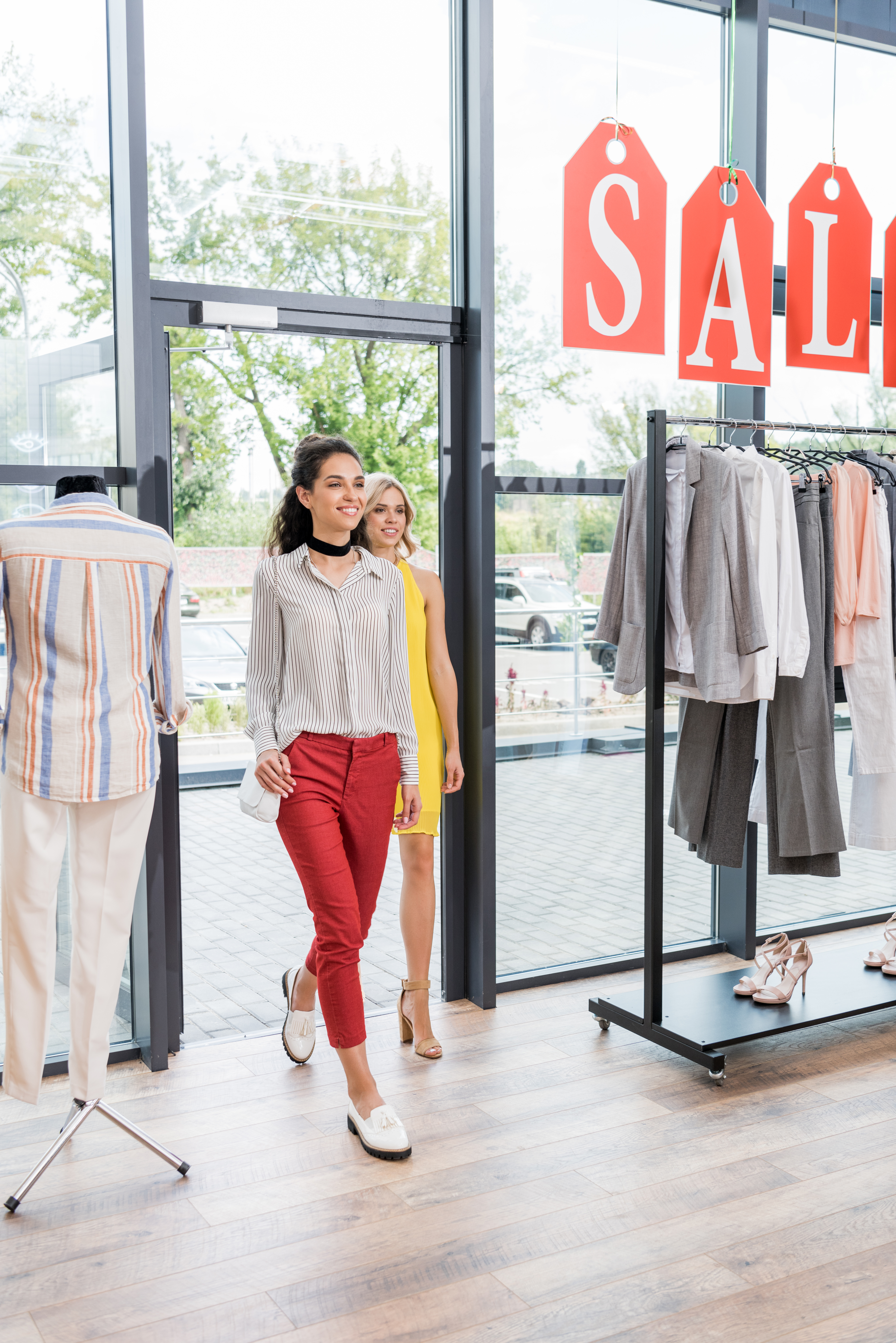 young beautiful women entering clothes store